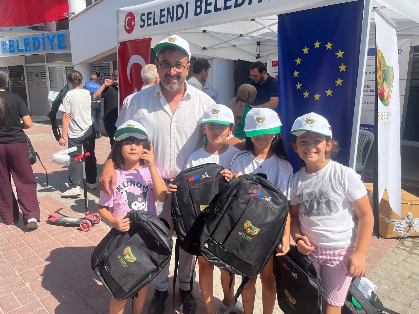 Çanta ve şapkalarını alan çocuklar